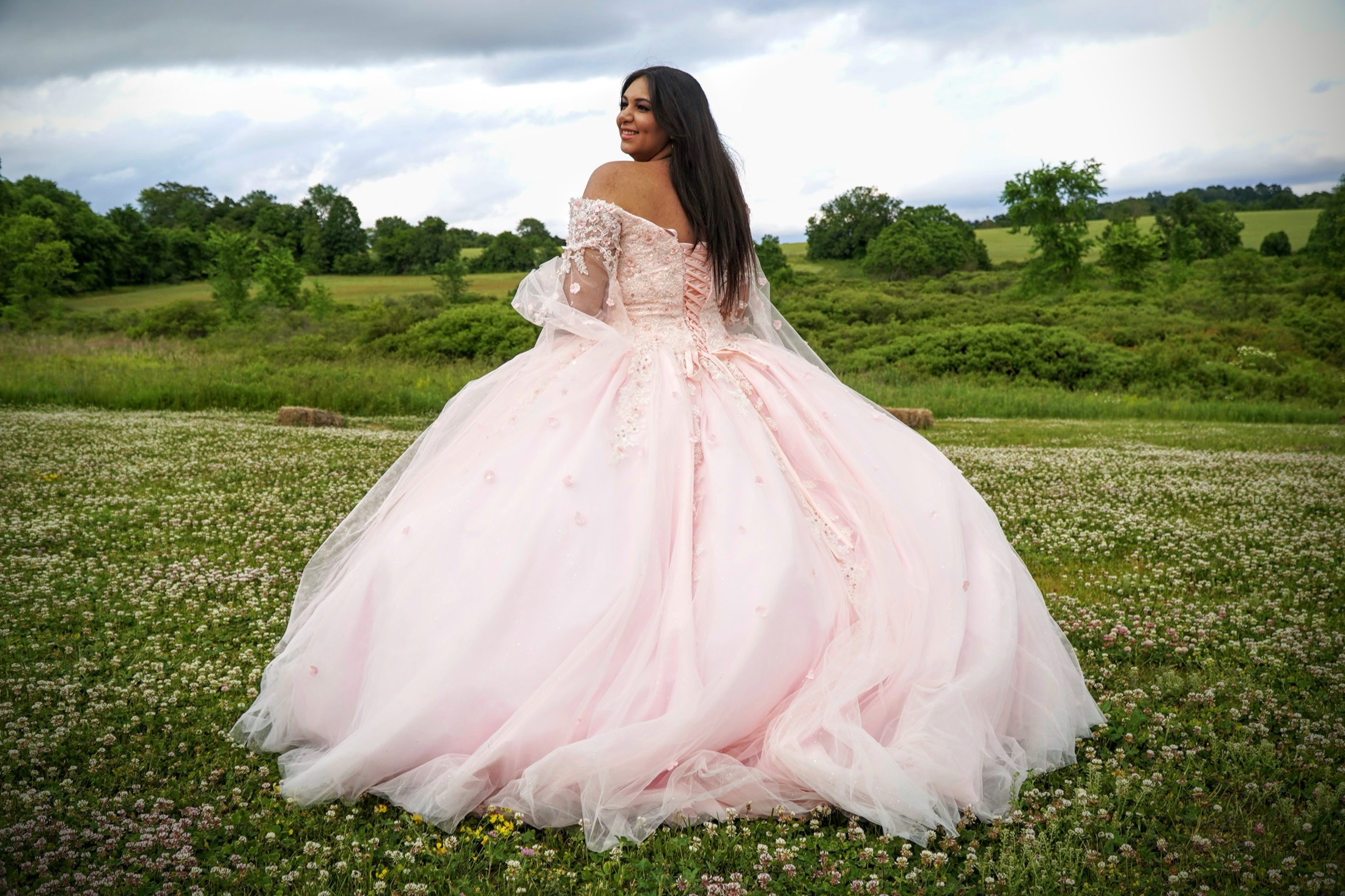 Young woman in a pink gown in an open field